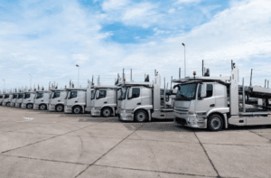 Foto di una lunga fila di camion con bisarca parcheggiati